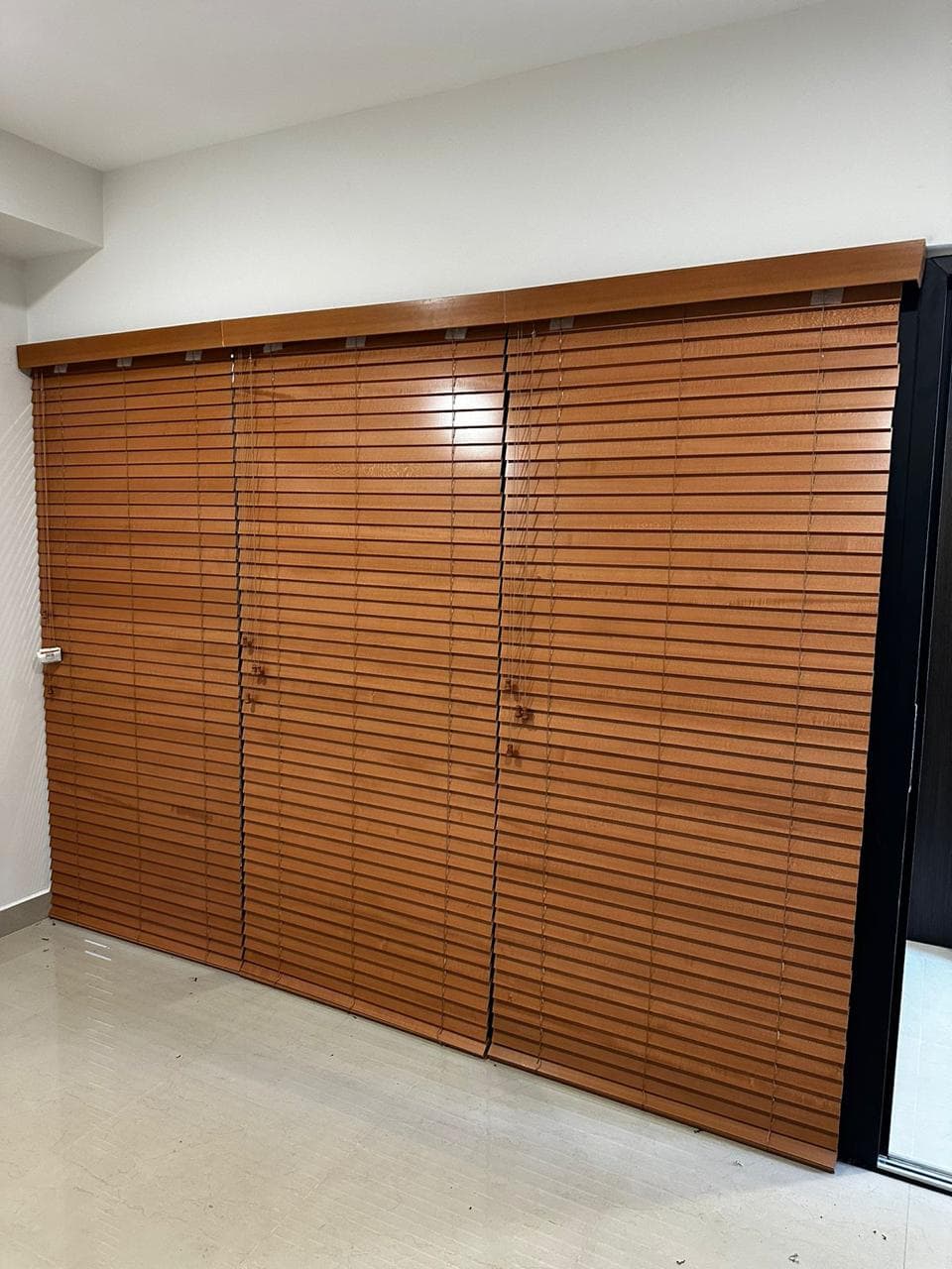 Persiana horizontal tono madera instalada en una ventana residencial