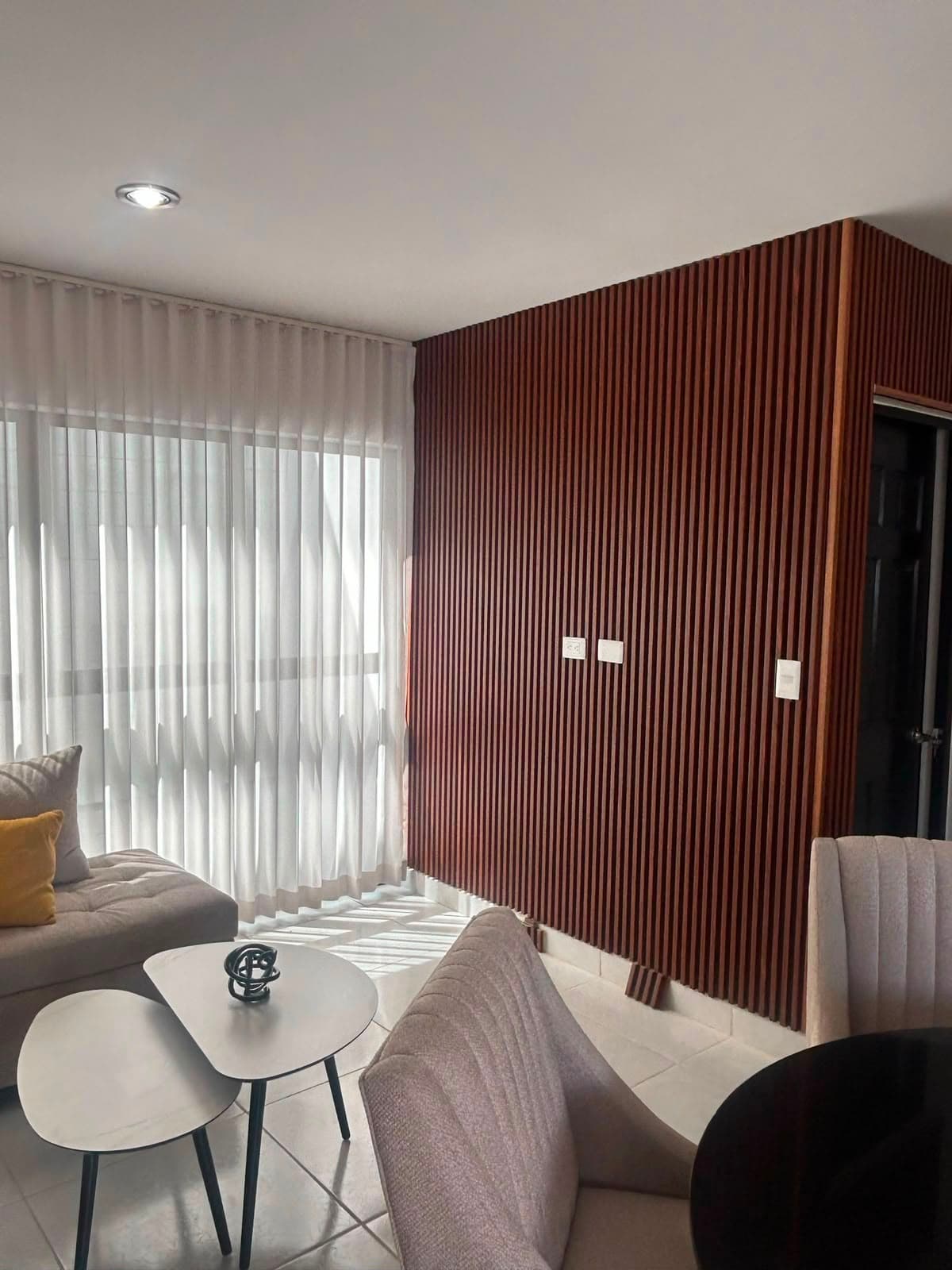Muro de sala terminado con recubrimiento tipo lambrín de madera