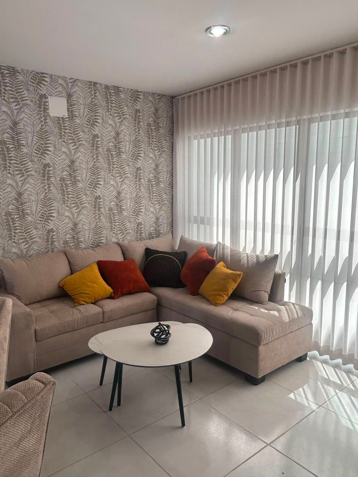 Sala terminada con tapiz de helechos y cortinas claras